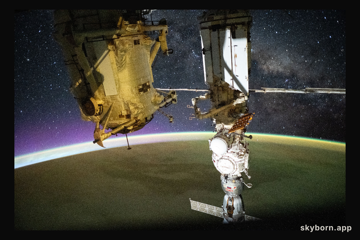 A yellow-green airglow blankets Earth as an orbital sunrise illuminates the planet
