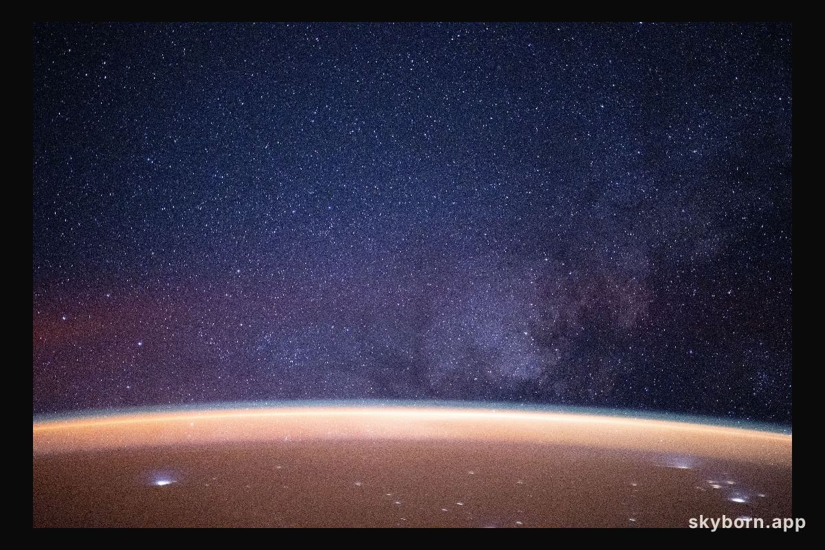 A reddish airglow blankets Earth beneath the Milky Way