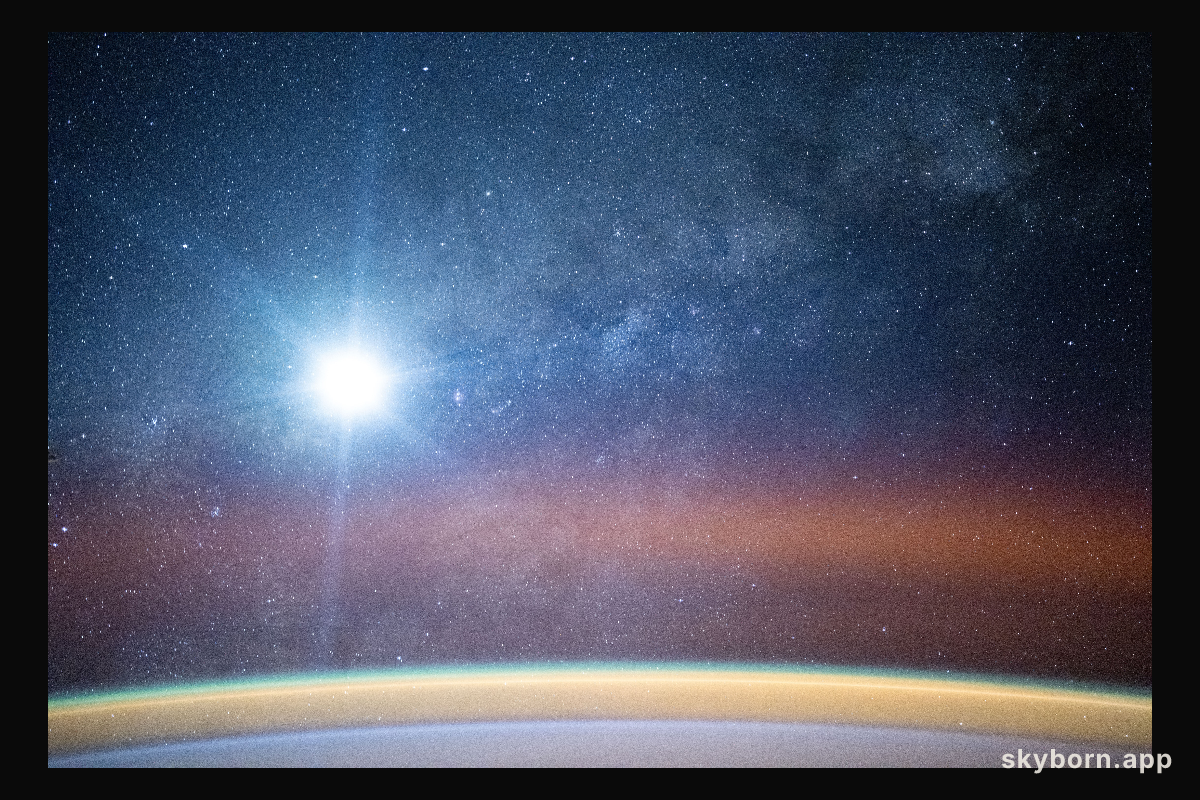 A bright airglow blankets Earth's horizon as the Milky Way illuminates the night sky