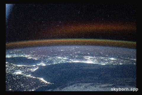 A red-yellow airglow blankets Earth's horizon above southwestern Europe and North Africa