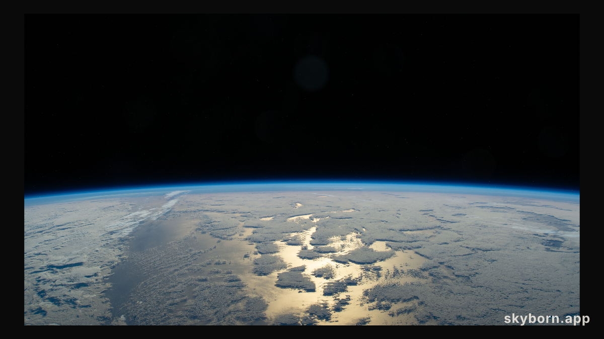 Earth's thin blue atmosphere traces the planet's horizon above the Pacific Ocean
