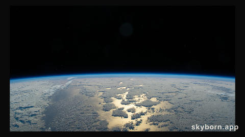 Earth's thin blue atmosphere traces the planet's horizon above the Pacific Ocean