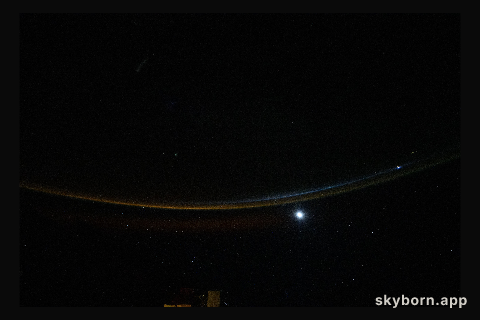 A dim airglow blankets Earth’s horizon as a faint Moon sets above the Indian Ocean