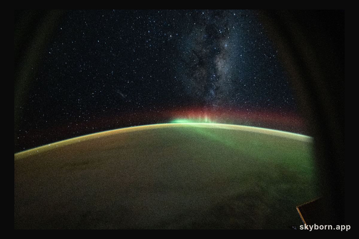 A wispy aurora australis arcs across the Indian Ocean benaeth the Milky Way